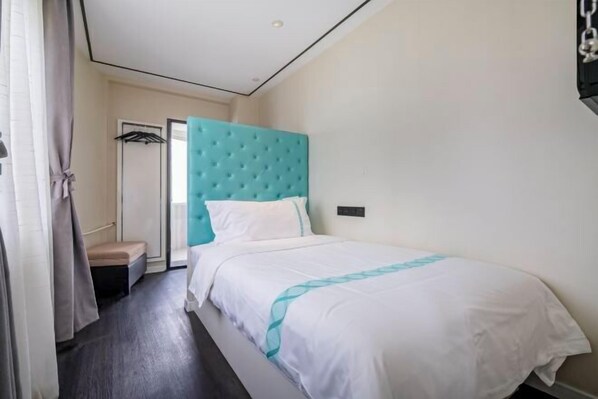 A hotel room with a bed, a headboard, a bedside table, a wardrobe, and a door. - Xana Hotelle Beijing Qianmen Tianqiao Subway Station (Beijing)