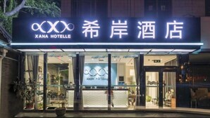 A hotel entrance with a neon sign reading "XANA HOTEL" and glass doors. - Xana Hotelle Beijing Qianmen Tianqiao Subway Station (Beijing)