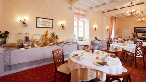 Ein Essbereich mit runden Tischen, Stühlen und einem Buffet mit Speisen und Getränken.
