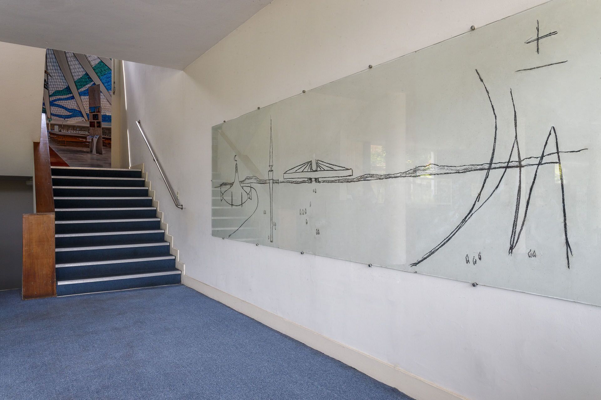 A staircase leading to a room with a large abstract painting on the wall.