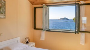 A bedroom with a bed, bedside table, lamp, and a window with curtains. - Holiday Home Melanie (Blato)