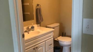 Een bad/douchecombinatie, een haardroger, handdoeken, toiletpapier