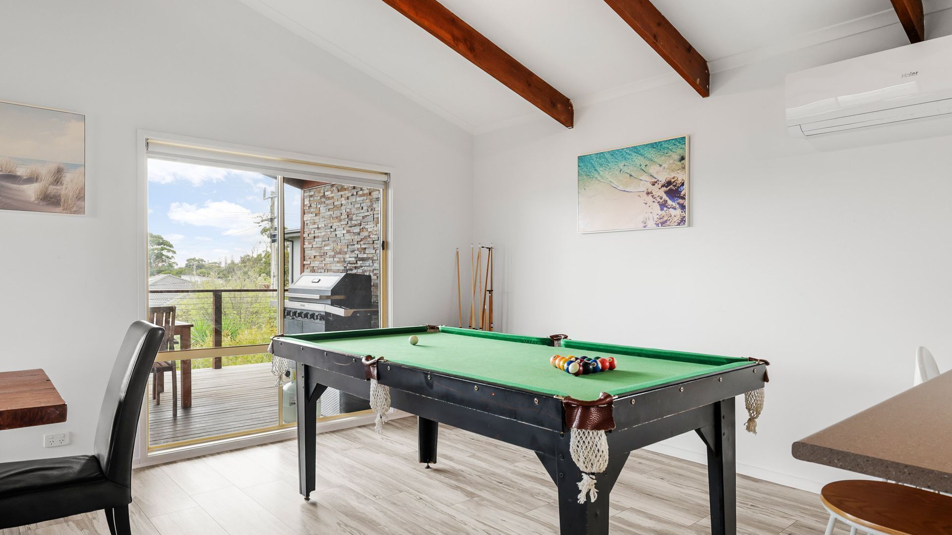 A pool table in a room with a view to the outside.