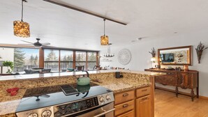 A modern kitchen with granite countertops, a stainless steel stove, and pendant lighting. - Cozy Mountain Home| 3BR• Sleeps 7 • Spacious Mountain Retreat (Vail)