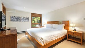 A bedroom with a wooden bed, bedside tables, a desk, and a window with blinds. - Modern Vail Retreat | King Suite + Bunk Room • Stone Fireplace • Huge Patio (Vail)