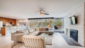 En moderne stue med en hjørnesofa, et glasbord og en pejs.