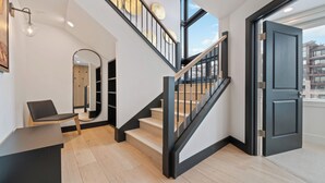 Et moderne interiør med trappe, siddeområde og en dør til udendørs.