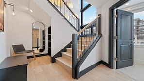 Ein modernes Interieur mit einer Treppe, einer Sitzecke und einer Tür, die nach draußen führt.