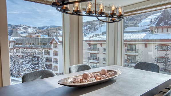 A dining area with a view of a snowy mountain resort.