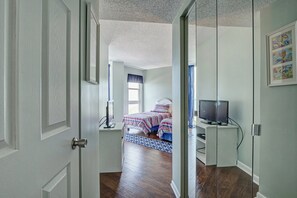 Ein Schlafzimmer mit einem Bett, einem Fernseher und einem Schreibtisch.