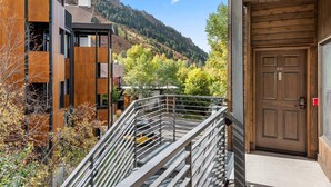A modern building with a wooden door, a metal staircase, and a view of a mountain. - Durant Condos by iTrip Aspen Snowmass (Aspen)