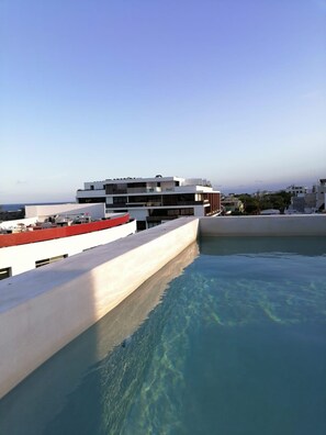 Una piscina al aire libre, sillones reclinables de piscina