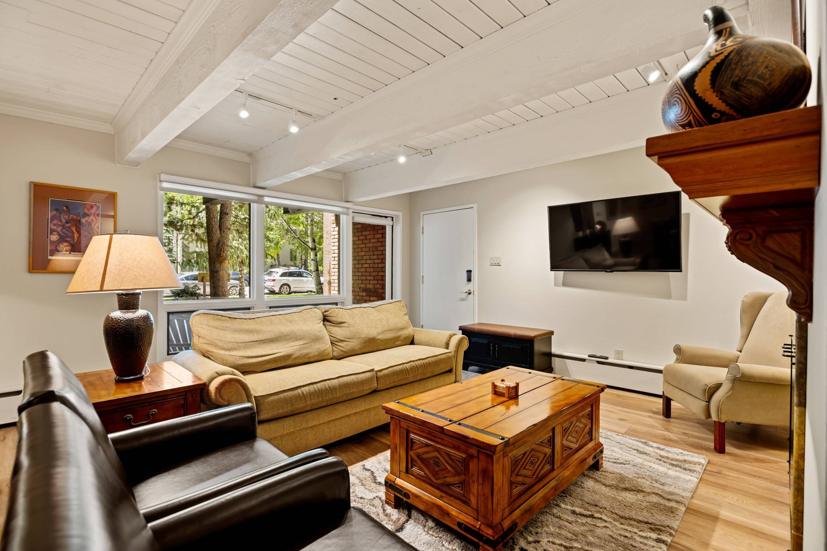 A spacious living room with a sofa, a coffee table, and a television.