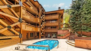 Un bâtiment en bois à plusieurs étages, avec une piscine située dans la cour intérieure.