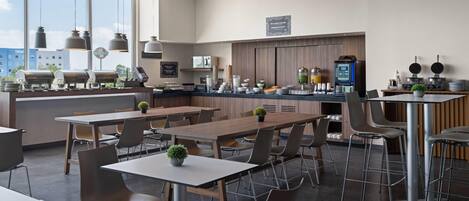 A modern restaurant with a bar area, multiple seating options, and a view of the cityscape.