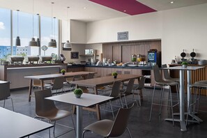 A modern restaurant with a bar area, multiple seating options, and a view of the cityscape. - Hotel MX mas cuautitlan Izcalli, Trademark by Wyndham (Cuautitlan Izcalli)