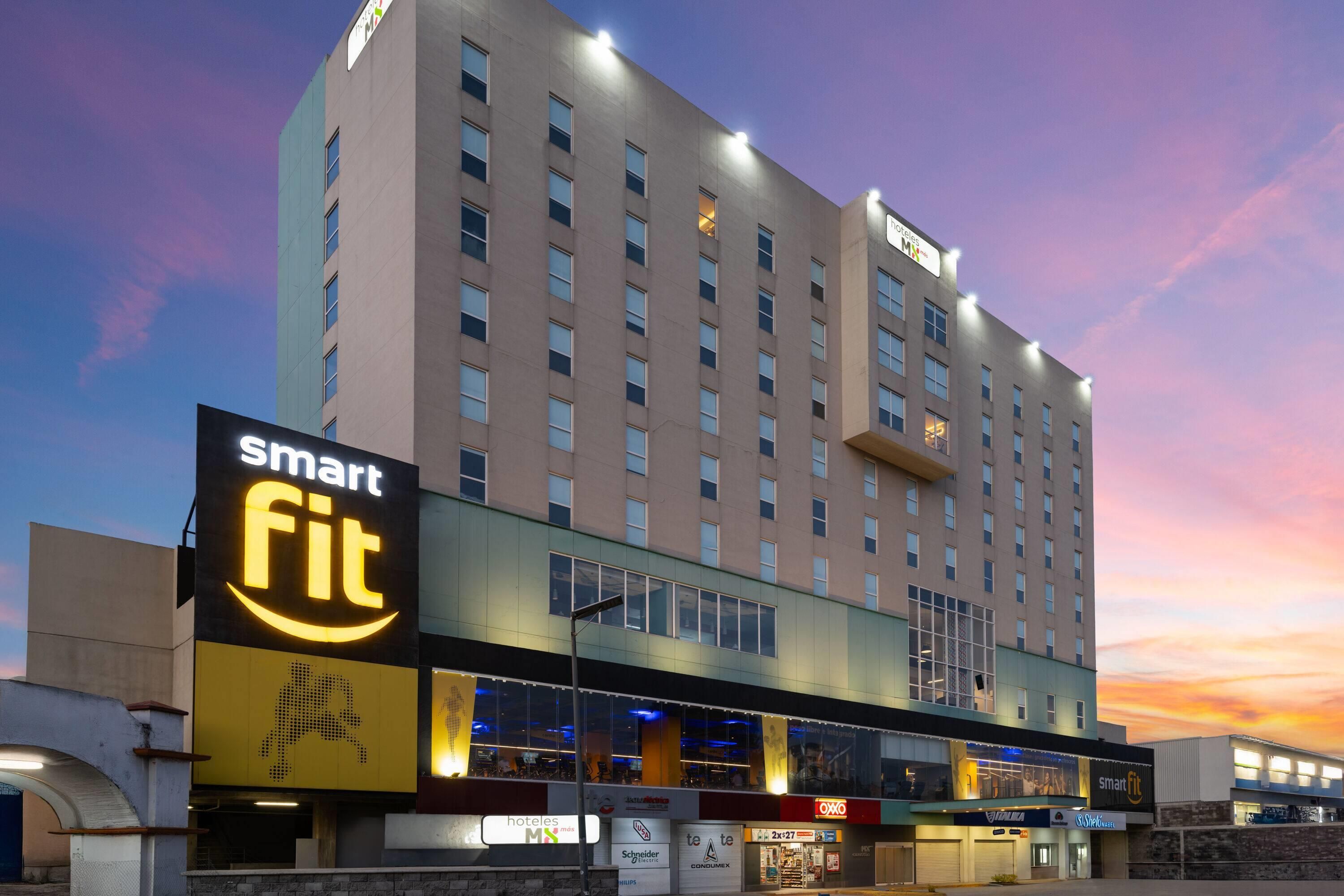 Een hotel met een opvallend 'Smart Fit'-bord, meerdere verdiepingen en diverse winkels op de begane grond.