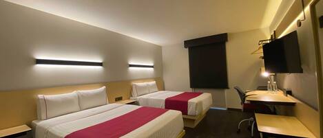 A hotel room with two beds, a desk, a chair, a TV, and a projector screen.