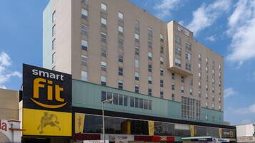 Un hotel de varios pisos con un llamativo rótulo que dice 'smart fit' en la planta baja.