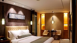 A hotel room with a large bed, a bedside table, a chair, a small table, and a wall-mounted artwork. - Beijing Minyoun Lia! by Minyoun Hotel (Wangfujing Commercial Street Dongdan Subway Station) (Beijing)
