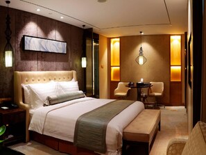 A hotel room with a large bed, a bedside table, a chair, a small table, and a wall-mounted artwork. - Beijing Minyoun Lia! by Minyoun Hotel (Wangfujing Commercial Street Dongdan Subway Station) (Beijing)