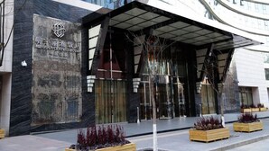 The exterior of the Minyou Central Hotel with a modern design, featuring a prominent entrance and a landscaped area with planters. - Beijing Minyoun Lia! by Minyoun Hotel (Wangfujing Commercial Street Dongdan Subway Station) (Beijing)