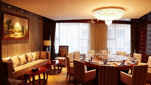 A hotel room with a dining area, a sofa, a chandelier, and a painting on the wall. - Beijing Minyoun Lia! by Minyoun Hotel (Wangfujing Commercial Street Dongdan Subway Station) (Beijing)