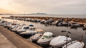 Ein Yachthafen mit Booten, die an einer Steinmole vertäut sind.