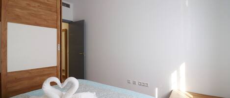 Une chambre d’hôtel avec un lit, une armoire en bois et une table de chevet.