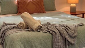 A neatly made bed with a green bedspread, a beige blanket, and a brown knitted throw. - 3 Bed Budget Brisbane Gem With Parking Near Gabba (Woolloongabba)