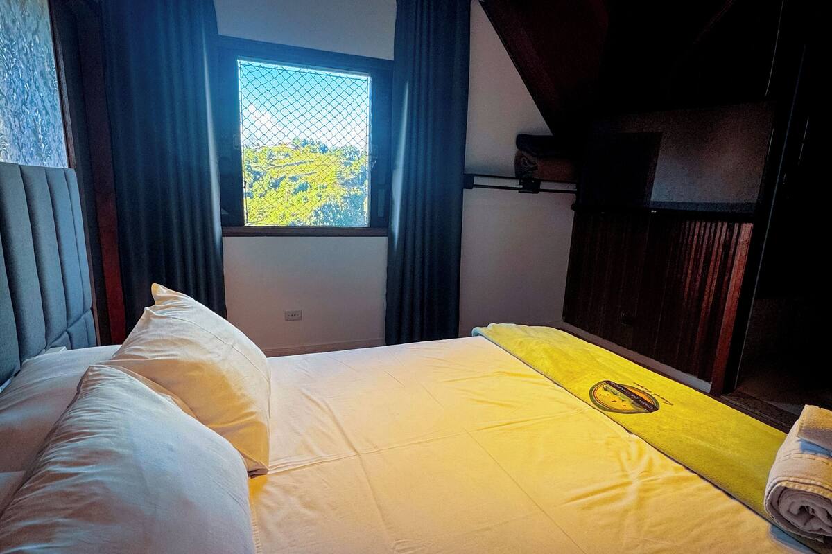 Een slaapkamer met een bed, een raam en een hoofdbord.