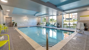 A pool area with clear water, yellow chairs, and a lifeguard sign. - Home2 Suites Downtown Nashville/Metrocenter (Nashville)