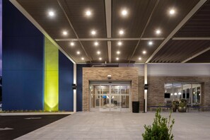 A modern building entrance with glass doors, a brick facade, and a flat roof with recessed lighting. - Home2 Suites Downtown Nashville/Metrocenter (Nashville)