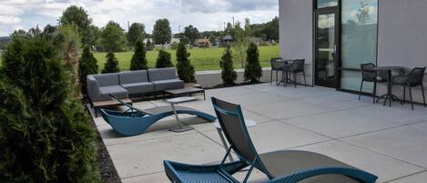 Un espace extérieur aménagé en terrasse, avec des sièges et une vue sur le paysage environnant.