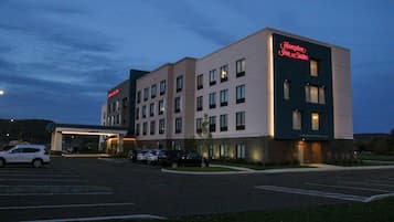 A Hampton Inn & Suites hotel with a parking lot and a building entrance.