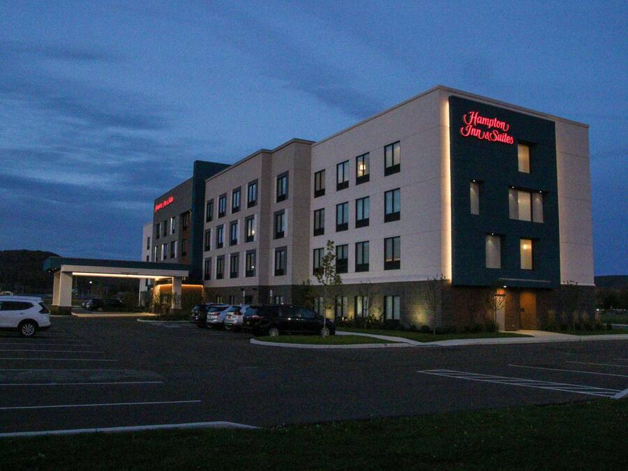 A Hampton Inn & Suites hotel with a parking lot and a building entrance.