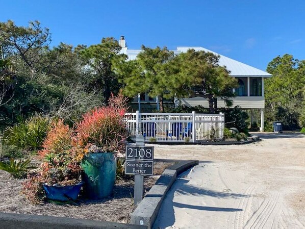 A residential property with a house number 2108, surrounded by landscaped gardens and a white fence.
