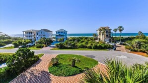 A coastal hotel with multiple buildings, a paved driveway, and a view of the ocean. - Welcome to Deja Vu! (St. George Island)