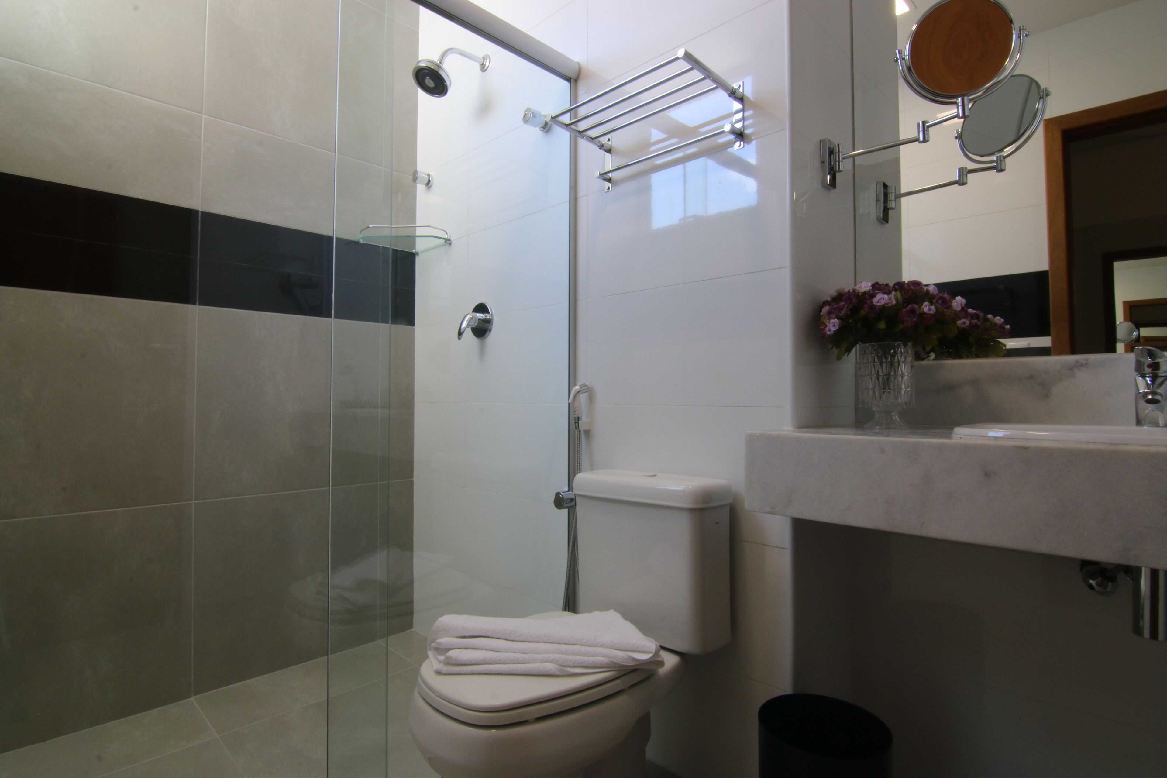 A bathroom with a toilet, shower, and sink.