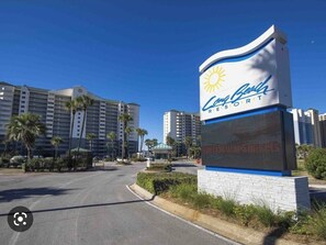 Une enseigne d’hôtel avec un logo représentant un soleil et le nom « Country Carver Resort ».