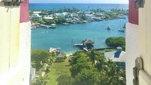 A view through an archway of a coastal area with boats, docks, and buildings.