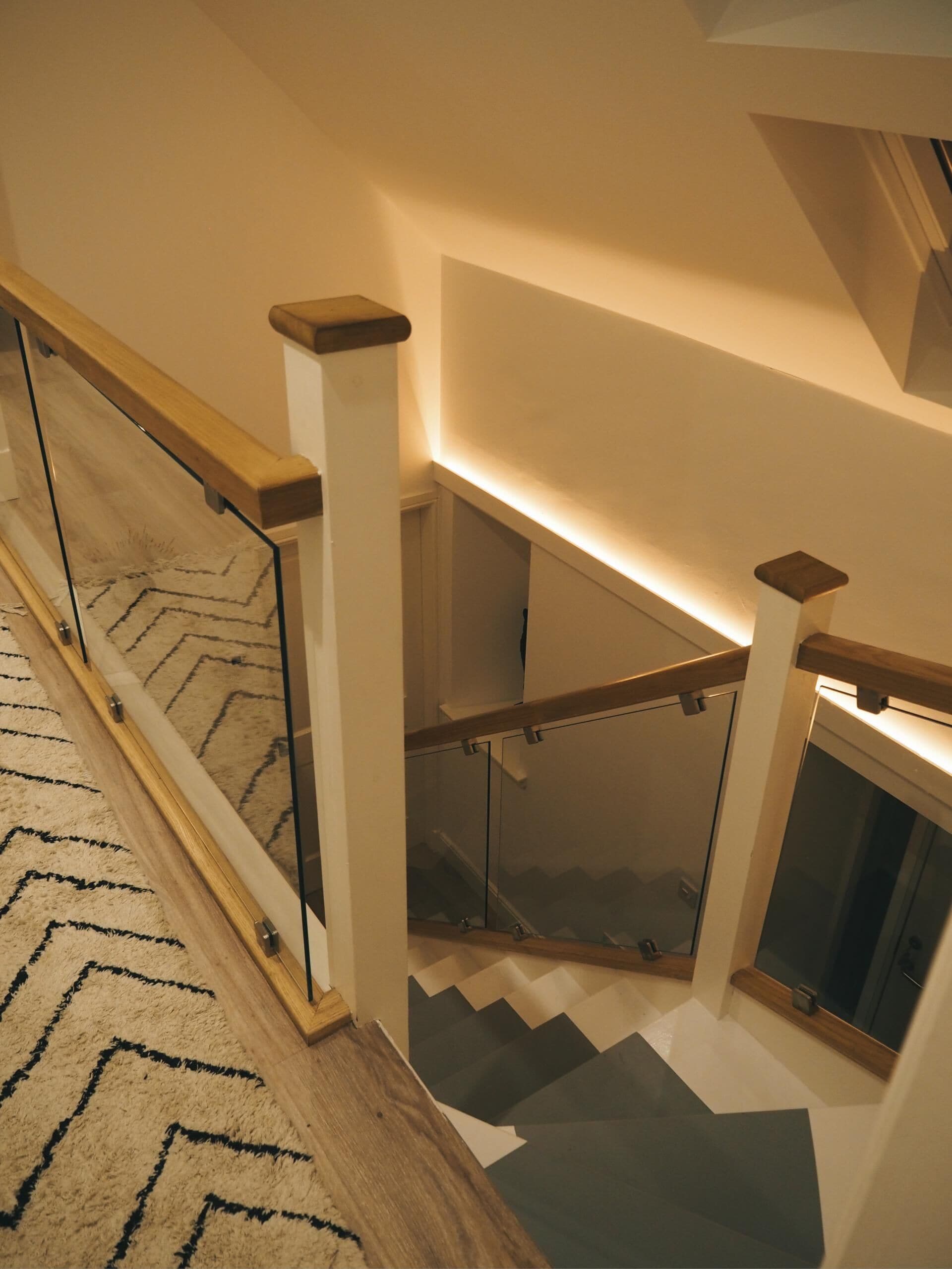A staircase with glass railings and wooden steps.
