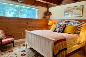 A bedroom with a wooden paneled wall, a bed with a white frame, and a floral-patterned rug. - Waterfront, Fall 2026, Goose Rocks Beach, Kennebunkport (Kennebunkport)