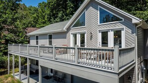 Een twee verdiepingen tellend huis met een balkon en een terras.
