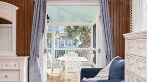 Ein Zimmer mit einem weißen Schminktisch, einem blauen Sofa und einem Essbereich mit weißen Stühlen und einem Tisch.
