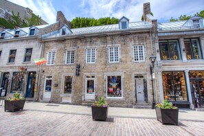 A historic stone building with multiple storefronts, including a visible shop with a sign that reads "MONT".