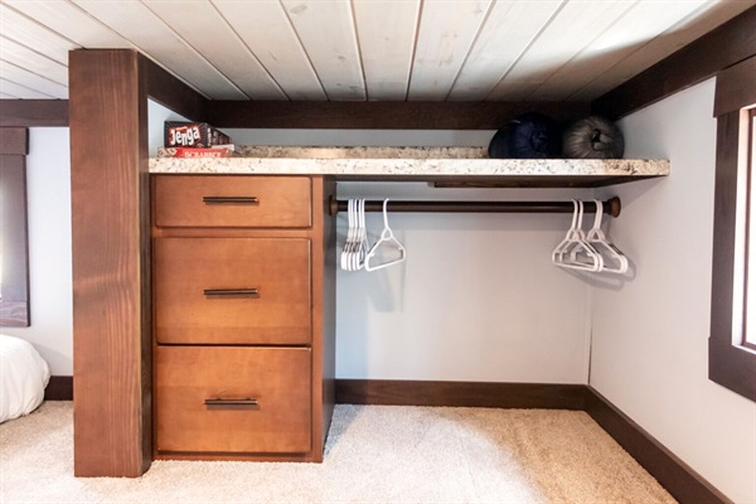 Habitación pequeña con un armario de madera, encimera y un perchero.