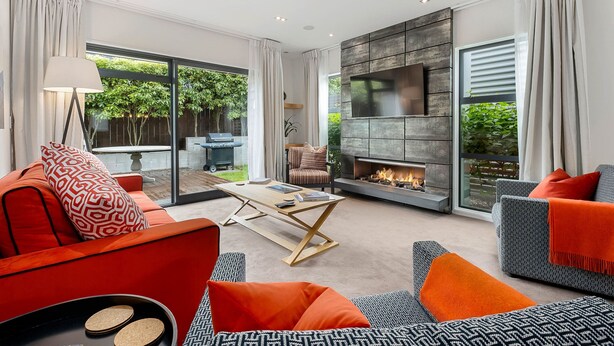 Un salon moderne doté d’une cheminée, de sièges confortables et de grandes fenêtres.