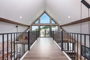 Stunning interior corridor with high ceilings, large windows, and rustic charm.