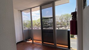 A room with a large window, tiled floor, and a red fire extinguisher. - Hotel Italia Aguascalientes (Aguascalientes)